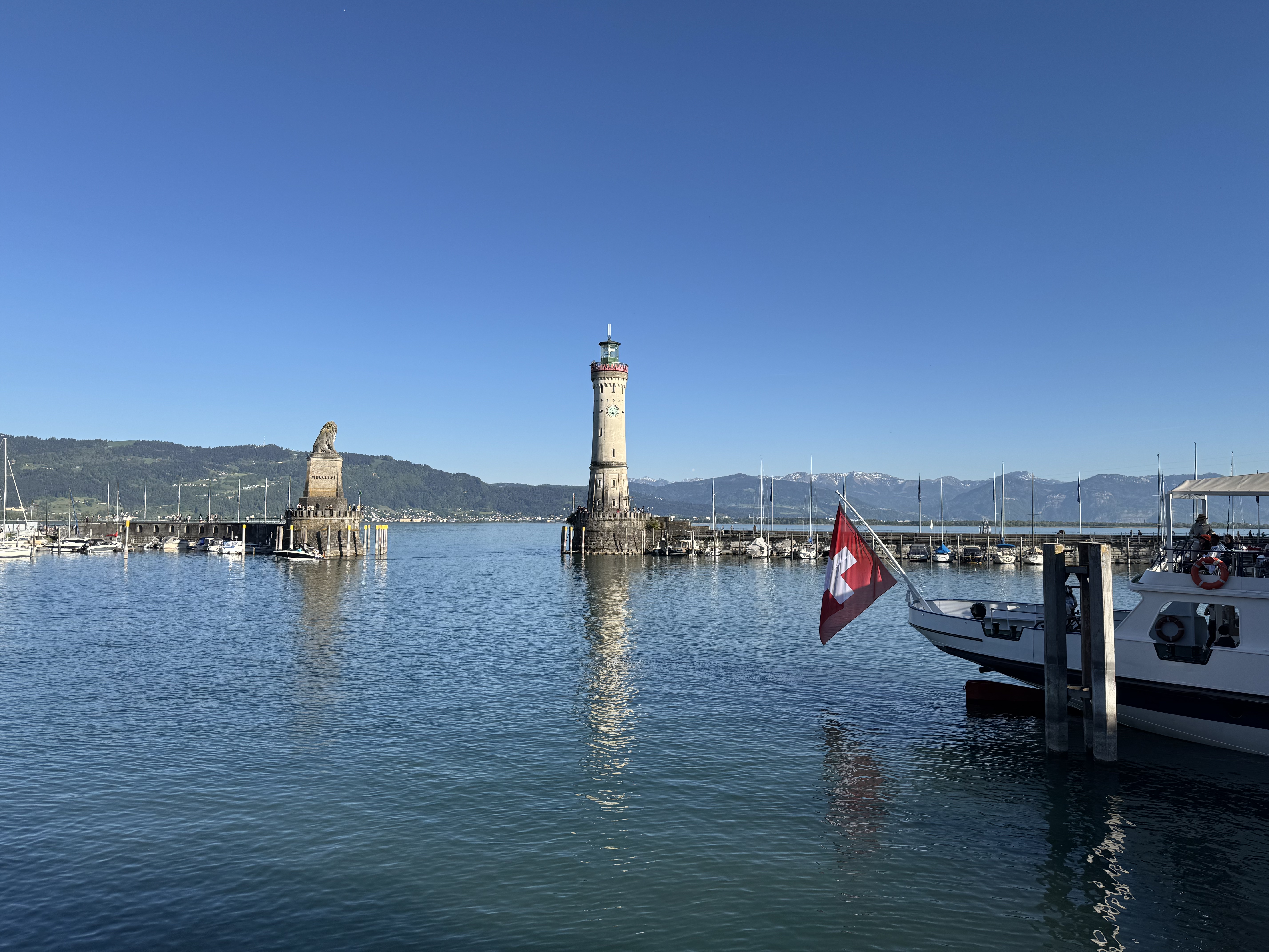 Hafeneinfahrt von Lindau am Bodensee mit Leuchtturm, Bayerischem Löwen und Schweizer Flagge